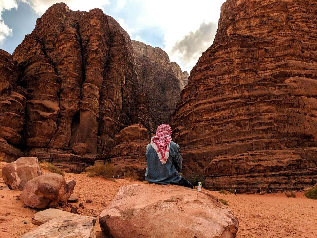 Bedouin Sitting At Entrance To Khazali Canyon